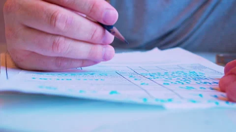 Hand filling out a paper document with a pen on a table. Stock Footage 336696490