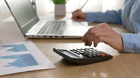 The hand of a financier is counting on a calculator using a laptop. Stock Footage 211755886