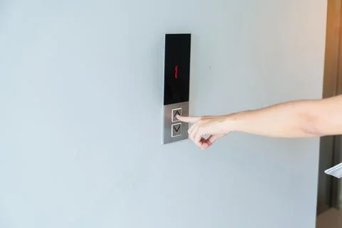 Hand finger press the Elevator button, woman waiting for Elevator in office o Fotos de archivo