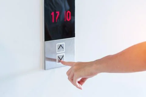 Hand finger press the Elevator button, woman waiting for Elevator in office o Stock Photos