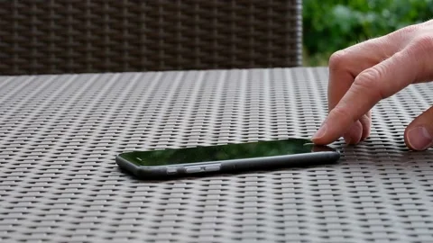 Hand finger presses and scrolls on the smartphone on the table. Stock Footage 130670655