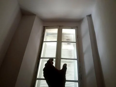 A hand finger try to catch window from living room. A hand silhouette Stock Photos