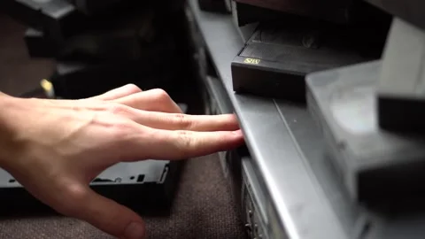 Hand, fingers insert a video cassette into VCR Video stock 234407429