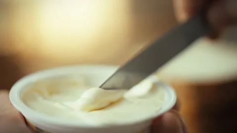 A hand firmly holds a sharp blade slicing through plastic wrapping to access Stock Footage 331313357