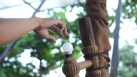 A hand is fixing the lamp on the fitting, which doesn't turn on because it's lax Stock Footage 272468958