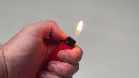 Hand Flicking and Igniting Red Plastic Lighter with Flame Burning Close-Up Stock Footage 340214632