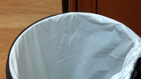 Hand flicks trash into garbage bin and shakes out carrot peels Video stock 123732579