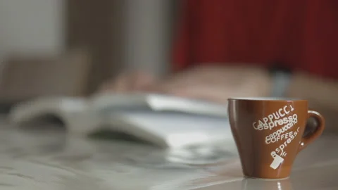 Hand Flipping Book Pages During Reading. Close Up shot with Cup of Coffee. Side Stock Footage 148201373