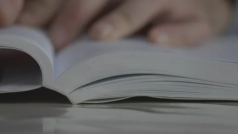 Hand Flipping Book Pages During Reading. Close Up shot. Guy Reading Book Stock Footage 148203368