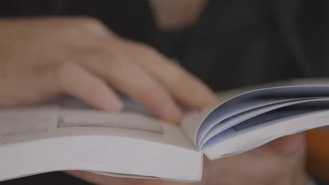 Hand Flipping Book Pages During Reading. Close Up shot. Boy Reading Book Stock Footage 148555939