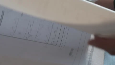 Hand flipping over page from architect plan Stock Footage 194605579