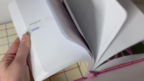 Hand flipping through a new notebook Stock Footage 304611480