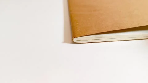 Hand flipping through a notebook, turning white lined paper pages on desk table Stock Footage 317135425