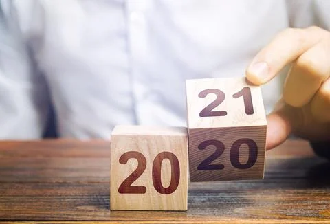 Hand flips a block changing 2020 to 2021. New year beginning. Holidays and .. Stock Photos