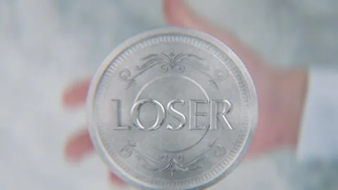 A hand flips a coin marked Winner and Loser, spinning toward the camera in .. Stock Footage 293790835