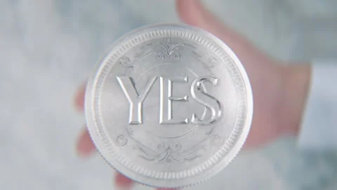 A hand flips a coin marked Yes and No, spinning toward the camera in slow m.. Stock-Footage 293790937