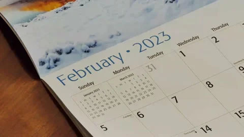 A hand flips through pages of the entire 2023 calendar year, month by month Vídeo Stock 228750470