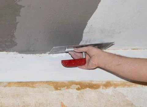 Hand with float aligns the ceiling with plaster Stock Photos