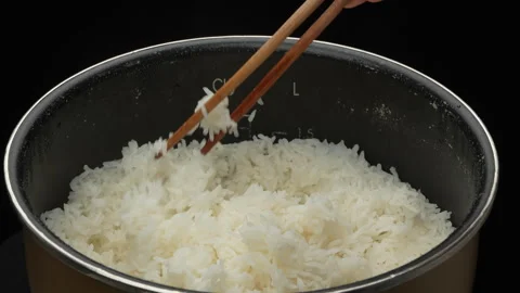 Hand Fluffing Hot Steaming White Rice With Chopsticks In Cooker 스톡 동영상 330940863