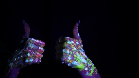 A hand with a fluorescent ethnic pattern shows a thumbs up. Fluorescent paint Stock Footage 233630544