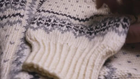 Hand folding a Norwegian pattern winter fashion wool jumper CLOSE-UP Stock Footage 308630143