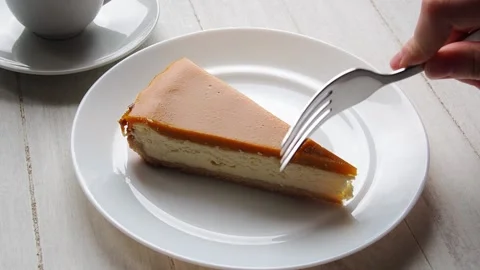 A hand with a fork breaks off a piece of cheesecake Stock Footage 171608386