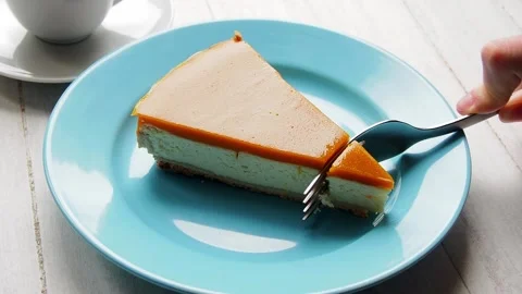 A hand with a fork breaks off a piece of cheesecake Stock Footage 171608388