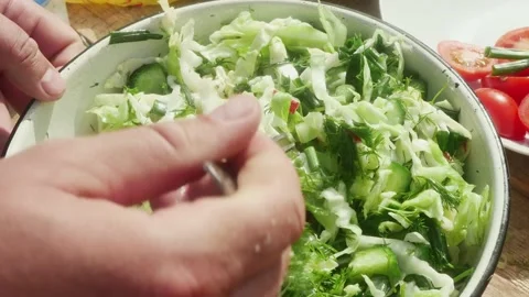 A hand with a fork mixes vegetables into a spring salad Vídeos de archivo 195395556