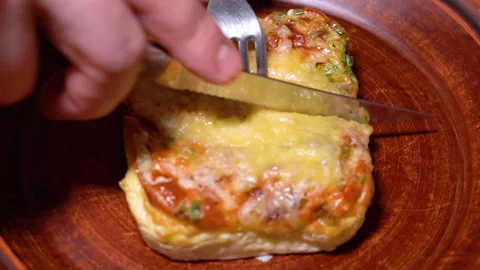 Hand with fork slicing omelet with fresh vegetables Stock Footage 249285857