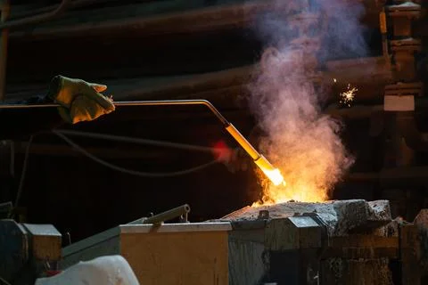 Hand of foundry worker measuring temperature of molten steel with ceramic probe Stock Photos