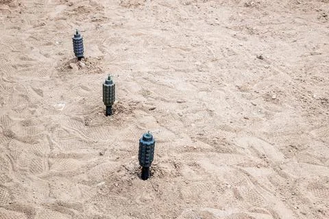 Hand fragmentation grenade mounted on the sand in a stretch Foto stock