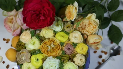 The hand in the frame puts live yellow and red roses on the cake. The pastry sho Stock Footage 143675059