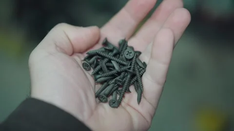 Hand full of black screws Stock Footage 300815966
