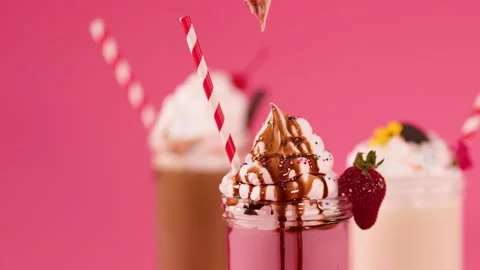Hand Garnishing Strawberry Milkshake with Cherry and Chocolate Drizzle Stock Footage 321666445