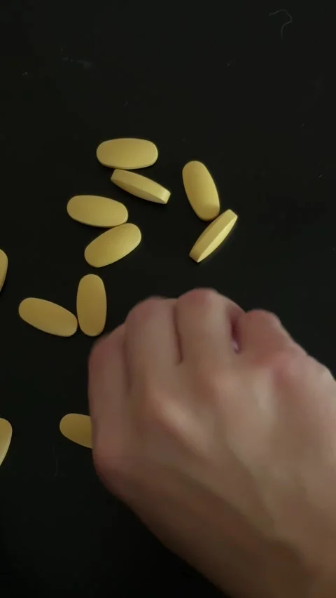Hand Gathering Yellow Tablets Top Down View 動画素材 340340992