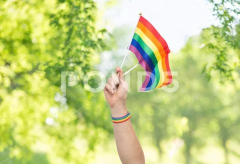 Hand with gay pride rainbow flags and wristband Stock Photos