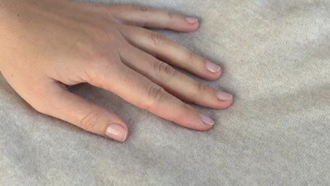 Hand gently gliding over sweater fabric highlighting softness and material Stock Footage 332875866