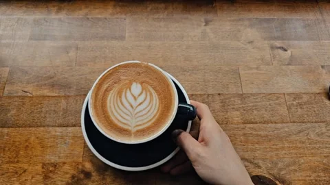 Hand gently holding a dark blue coffee cup with a saucer Stock Footage 316845352