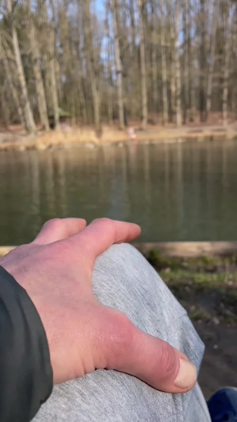Hand gently placed on knee against blurred wilderness background Video stock 347334293
