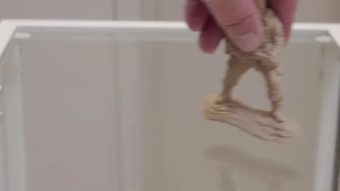 Hand Gently Places Beige Plastic Toy Soldier on Glass Tabletop with a Soft Thud Stock Footage 321346091