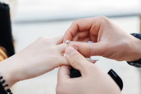 Hand gently places diamond ring on finger Foto stock