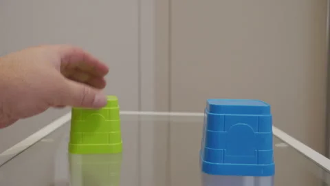 Hand Gently Places Plastic Stacking Cup on Glass, Creating Light, Hollow Clack. Stock Footage 321266675