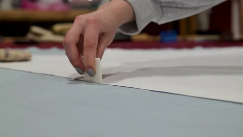 Hand gently presses white chalk on textured paper surface Stock Footage 340040071