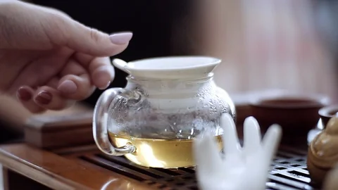 Hand gently removes from the kettle, a small sieve and puts it in place. Tea Stock Footage 111180137