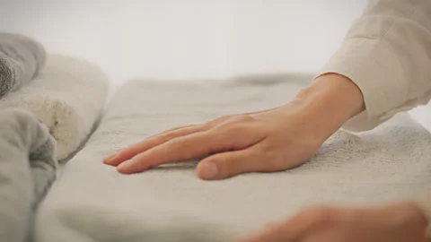 A hand gently touches a soft white towel Stock Footage 290356052