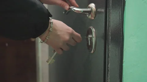 Hand gently unlocking door. Close shot of key entering lock. Cinematic depiction Stock Footage 342335558