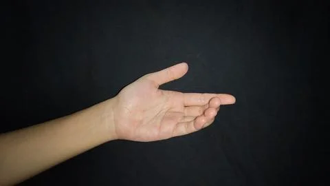 Hand with a gesture offering help isolated on black background 写真素材