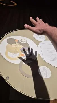 Hand Gesturing Over Abstract Circular Design Board Stock Photos