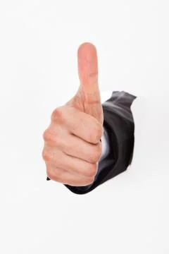 Hand gesturing thumbs up through white wall Stock Photos