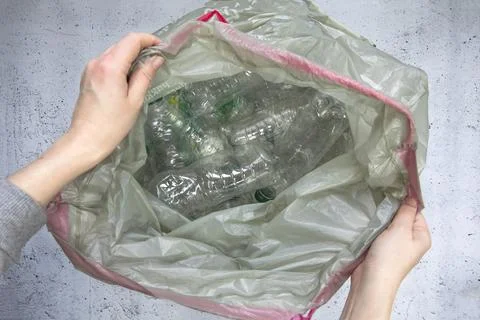 Hand getting plastic bottles to dispose in garbage bag ready to recycle, waste Stock Photos